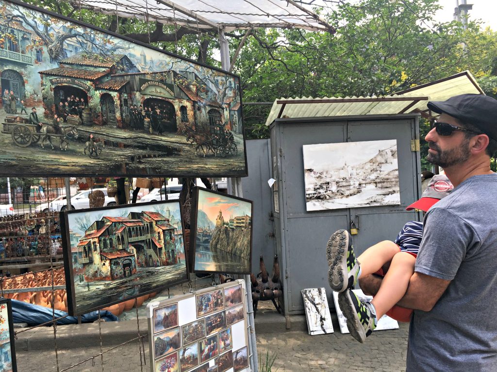 Man looking at displayed paintings at the Dry Bridge