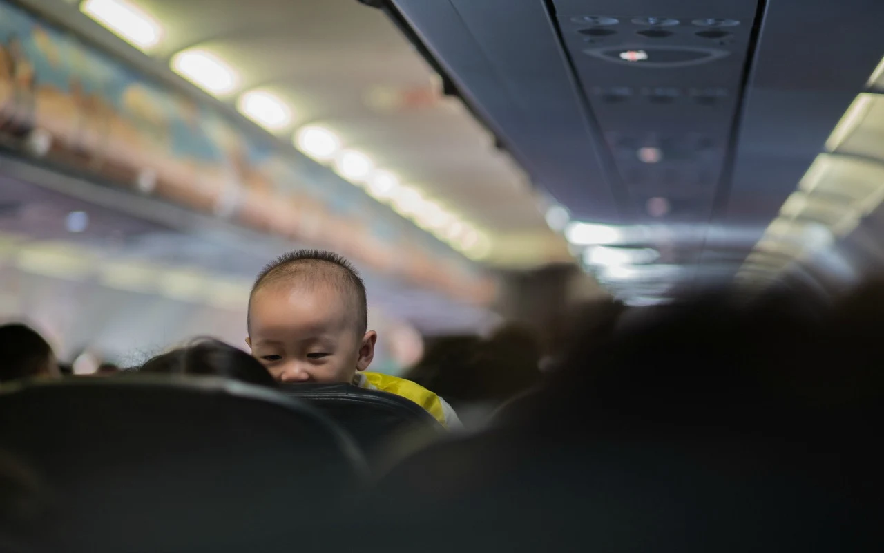 Child looking back over the seat on an airplane