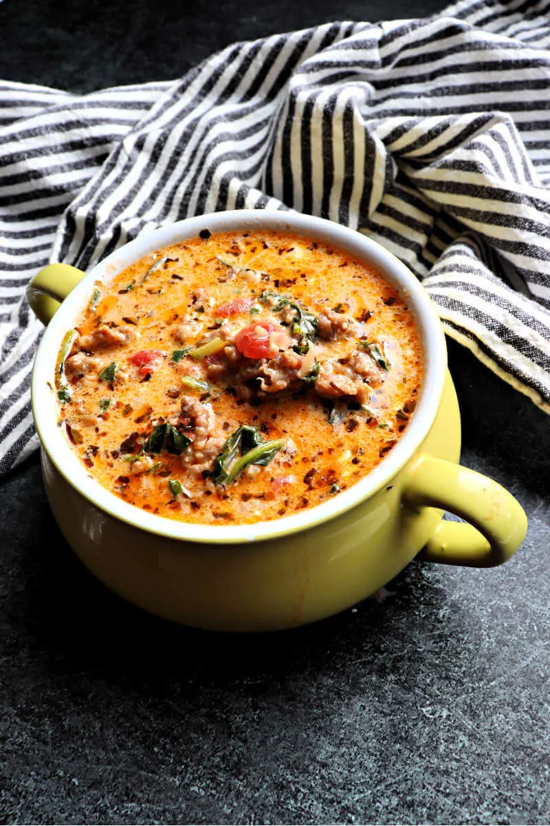 Creamy keto Italian sausage soup, aka Keto Zuppa Toscana. Delicious and gluten-free, low carb, and packed with protein and veggies to warm you up on a winter day. The perfect family dinner to meal prep on a keto diet. #ketodinners #ketosoups #ketosouprecipes