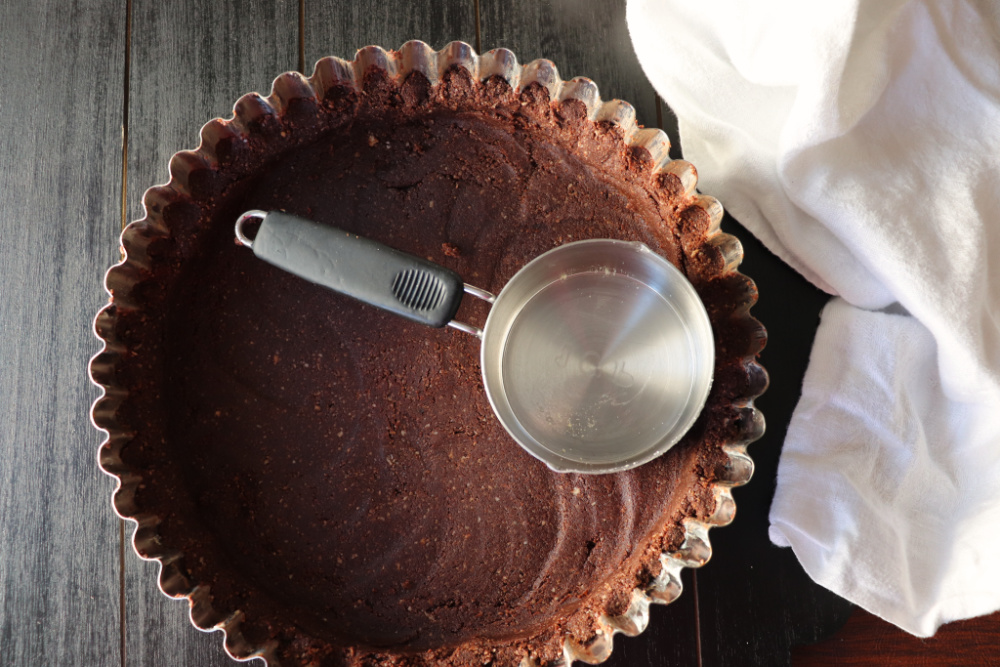Keto Peanut Butter Pie crust, use a measuring cup to press out the crust #ketocrust #ketopie