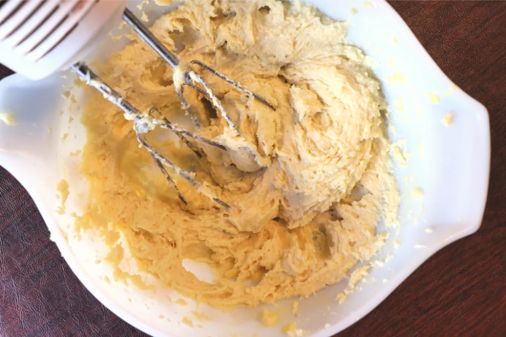 Keto cinnamon rolls batter being mixed with a hand mixer
