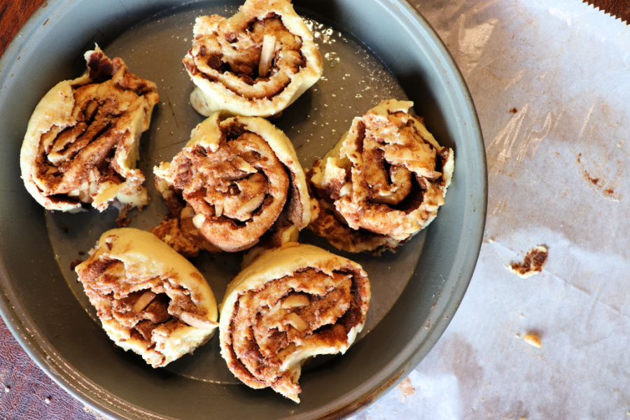 Raw keto cinnamon rolls in a circle pan to be baked
