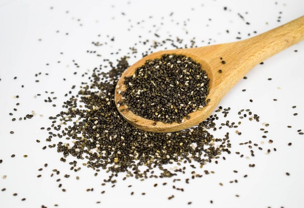 Chia seeds in a wooden spoon on a white background #chiaseeds #ketorecipes