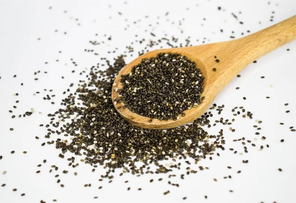 Chia seeds in a wooden spoon on a white background #chiaseeds #ketorecipes