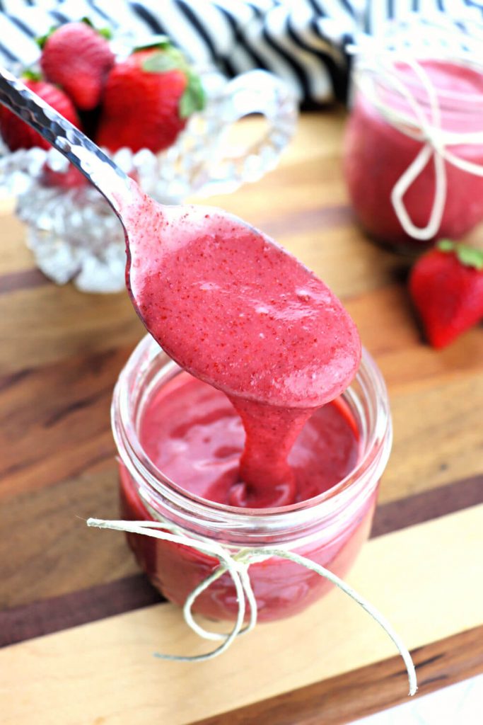 Spoon of keto strawberry jam thickens even more when refrigerated. Delicious and sugar-free! #sugarfreejam #strawberry
