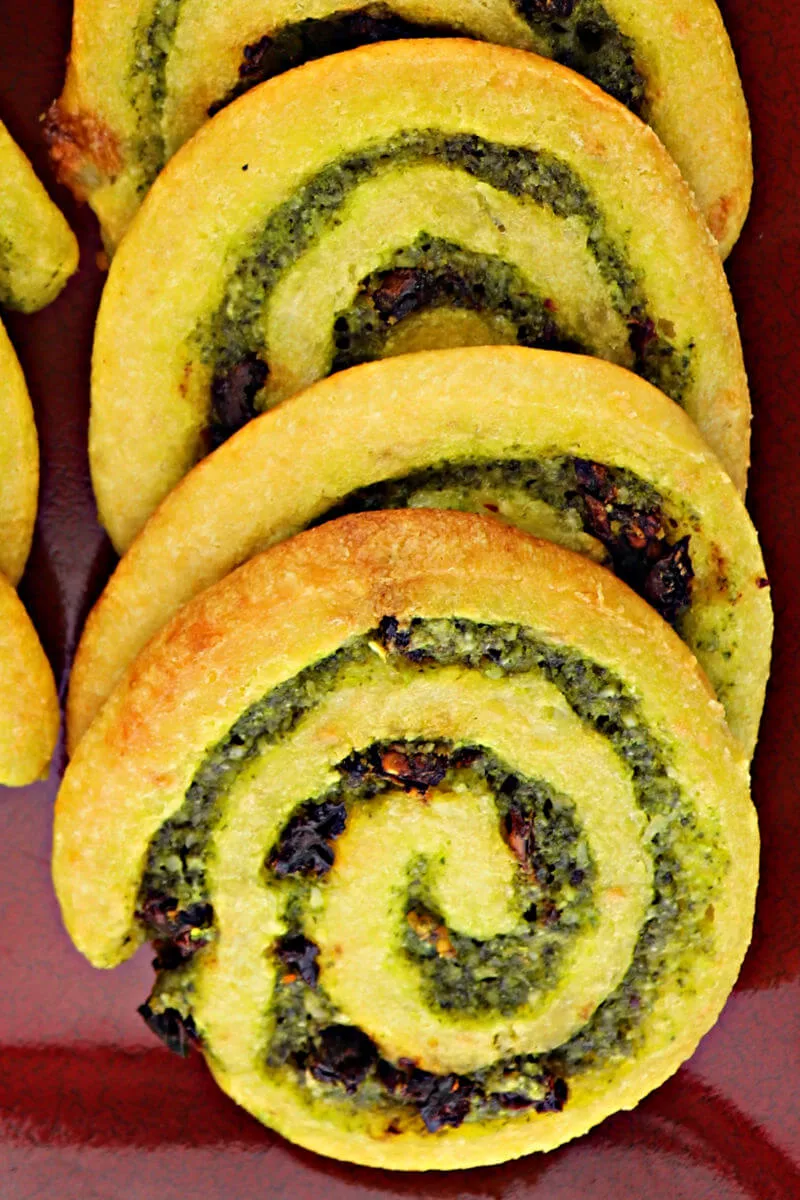 Delicious parmesan, basil, garlic, and sun-dried tomatoes flavor these keto pesto pinwheels. Perfect for a low carb appetizer or gluten-free game day snack. #ketoappetizer #glutenfreeappetizer