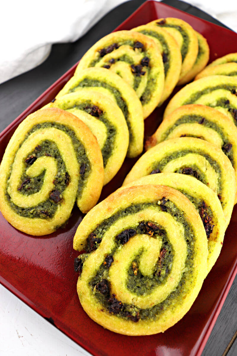 Flavorful parmesan, basil, garlic, and sun-dried tomatoes flavor these keto pesto pinwheels. Perfect for a low carb appetizer or gluten-free game day snack. #ketoappetizer #ketorecipes