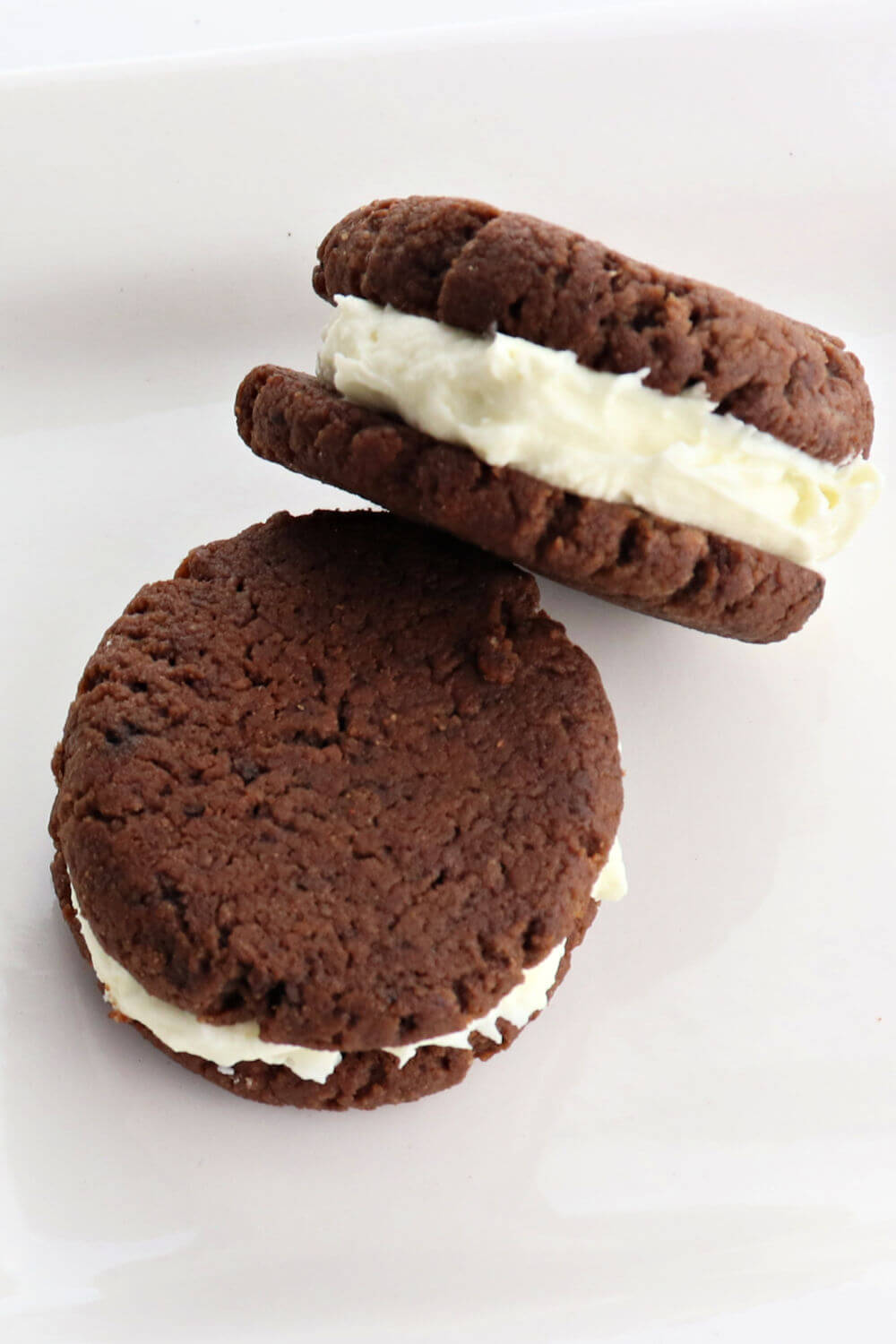 Low carb keto chocolate sandwich cookies on a plate are the perfect gluten-free snack. A cross between a keto oreo and a keto whoopie pie, these sugar-free treats are a family favorite. #ketorecipes #ketocookies