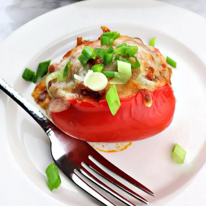 Italian keto sausage stuffed peppers are filled with gluten-free cauliflower rice, Italian sausage, mushrooms, and more. A family-friendly and delicious low carb dinner. #ketodinner #stuffedpeppers