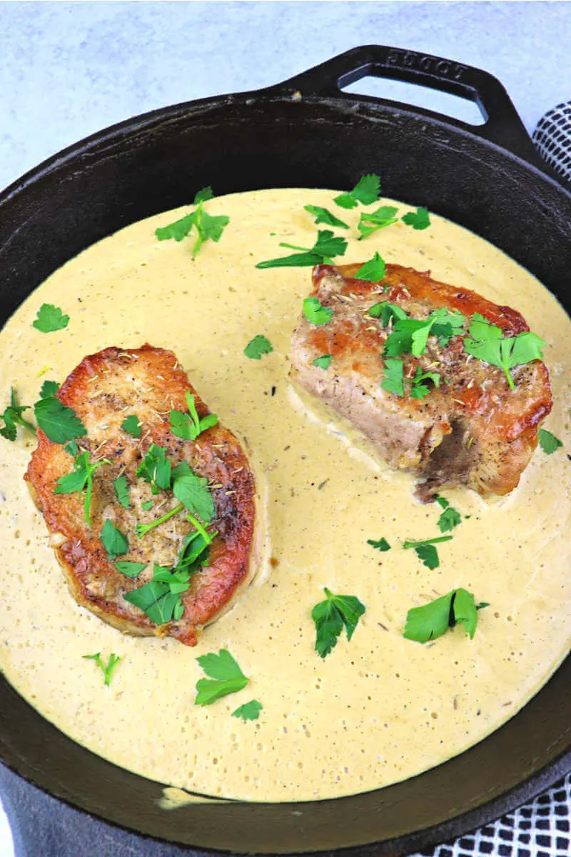 Creamy garlic keto pork chops are family dinner comfort food. Smothered or gluten-free gravy on the side, keto dinner served. #ketoporkchops #ketodinner 