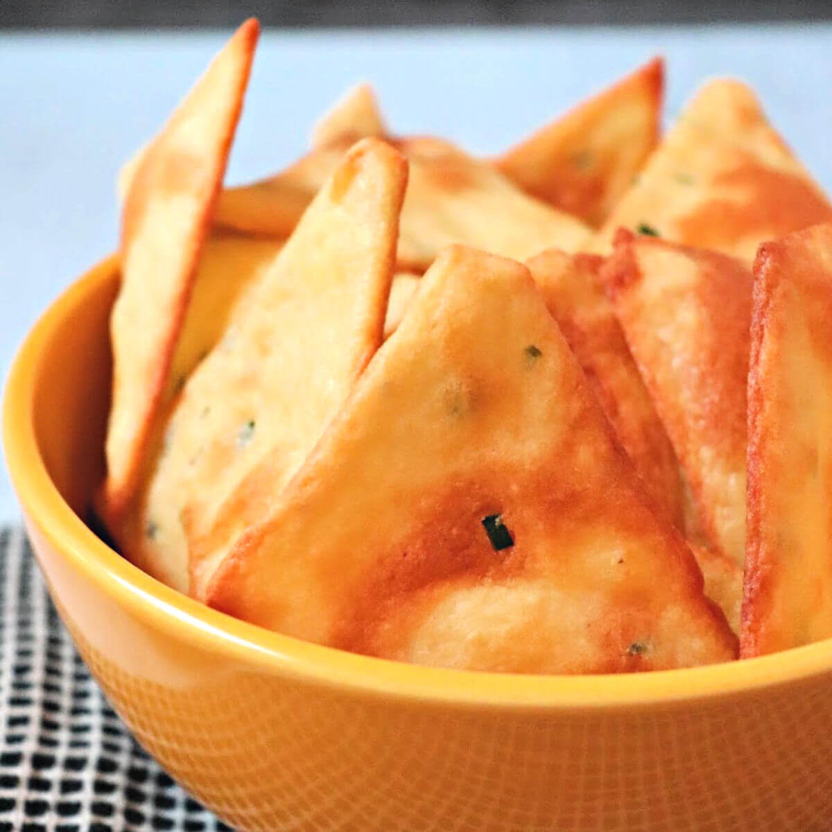 Delicious sour cream and onion keto chips in a bowl made with almond flour, cheese, and more real ingredients.