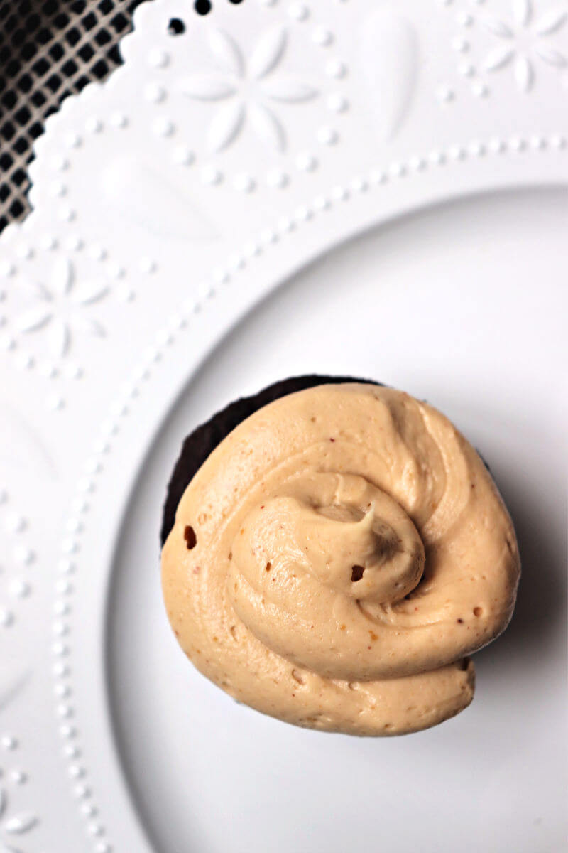 Keto peanut butter frosting overhead one gluten-free cupcake. #ketodesserts #ketofrosting