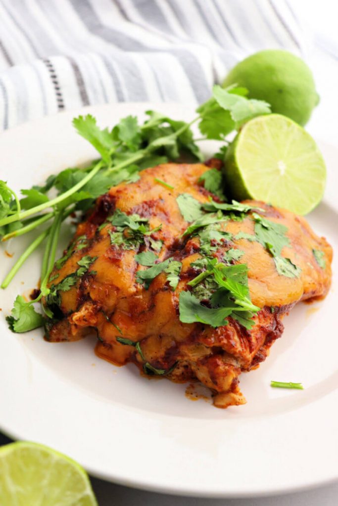 Two keto chicken enchiladas smothered in sugar-free enchilada sauce and cheese.