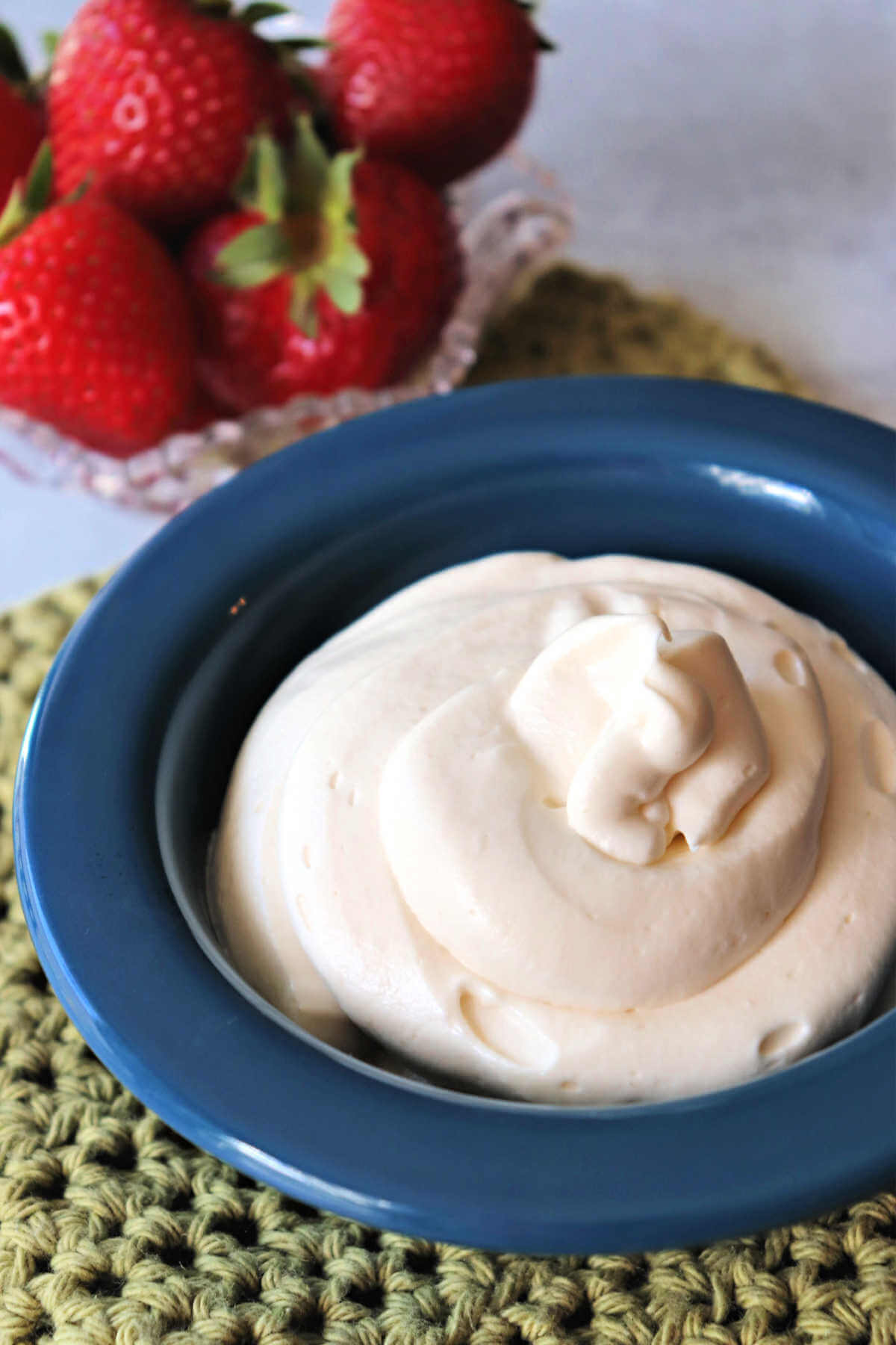 Bowl of keto cream cheese frosting with strawberries