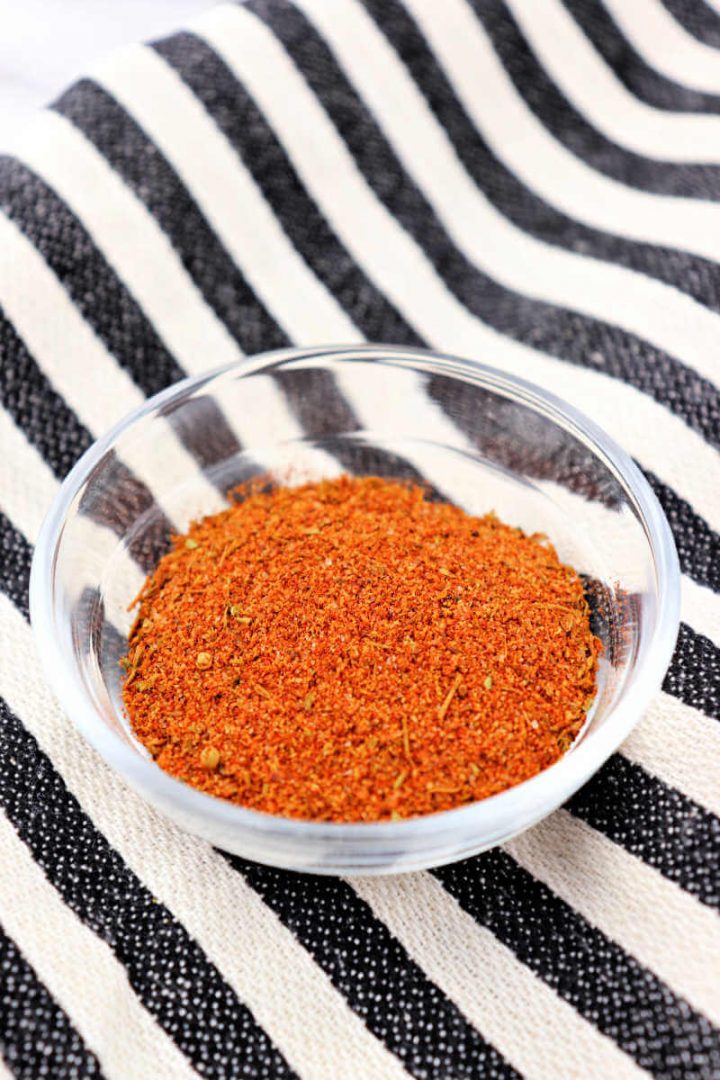 Small bowl of Cajun spice on a striped kitchen towel