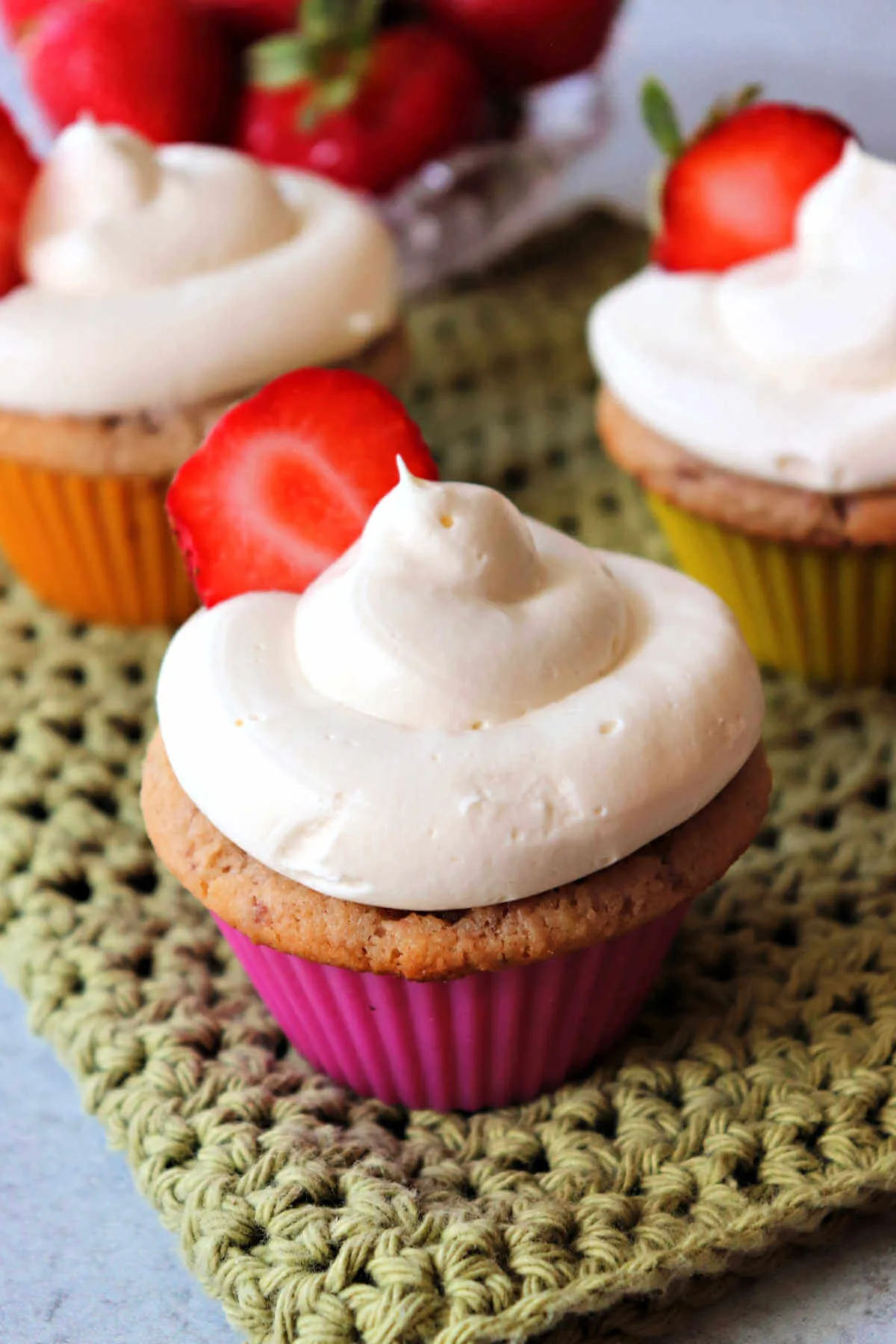 Keto strawberry cupcakes topped with sugar-free cream cheese frosting.