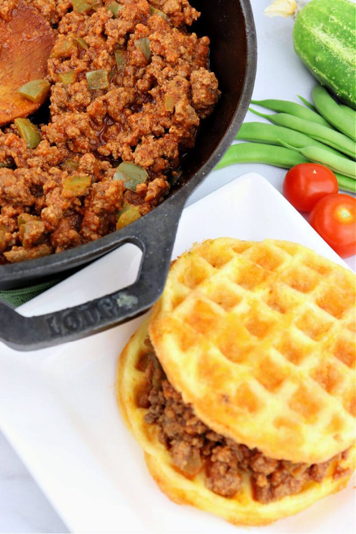 Cast-iron skillet with keto sloppy Joe mixture and a chaffle sloppy Joe