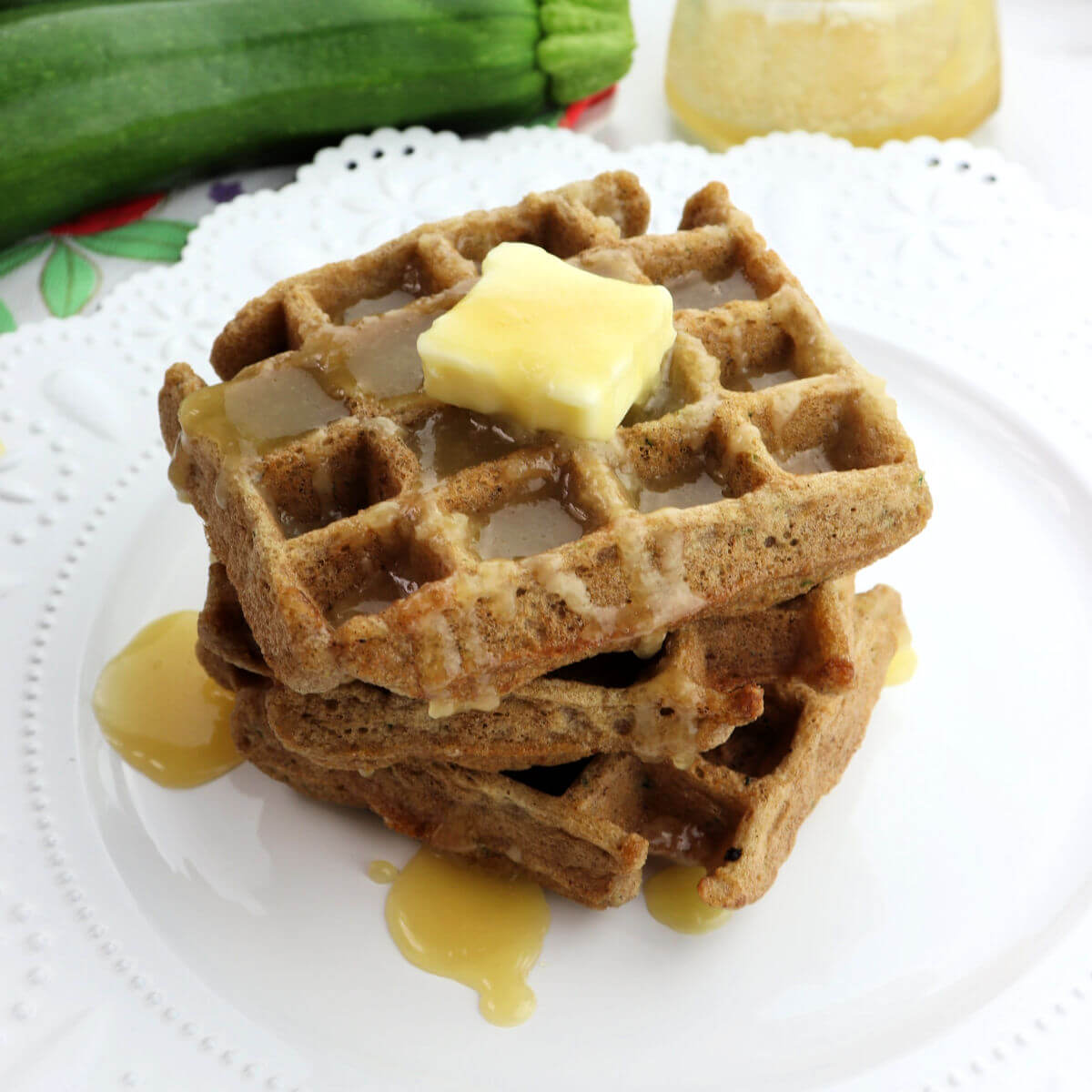 A stack of three keto zucchini waffles on a white plate.