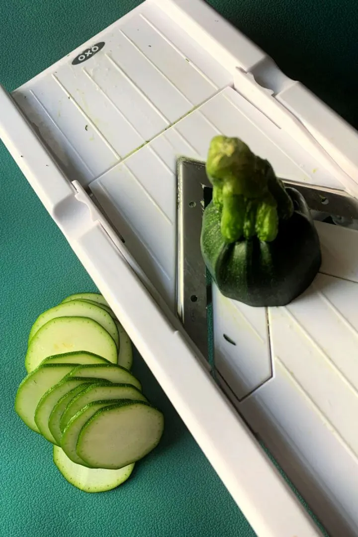 Slices of zucchini on a mandoline slicer