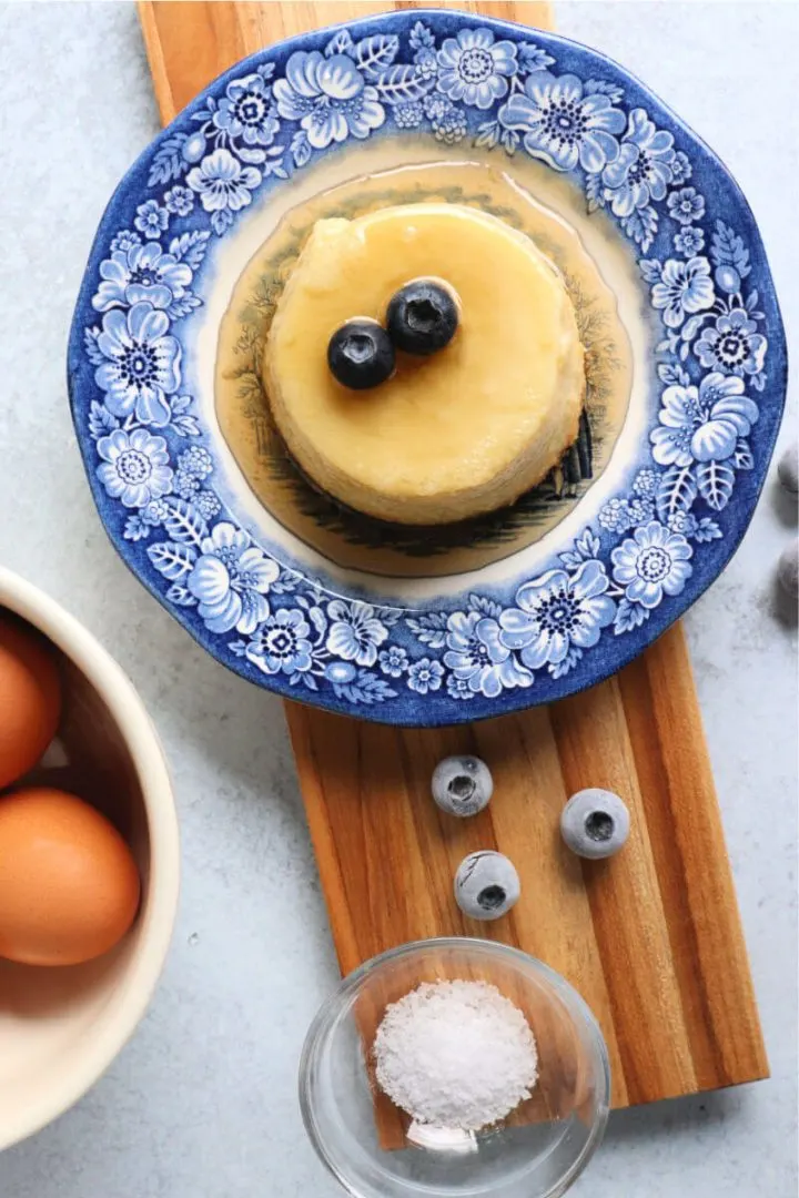 Overhead a serving of keto flan on a board with ingredients