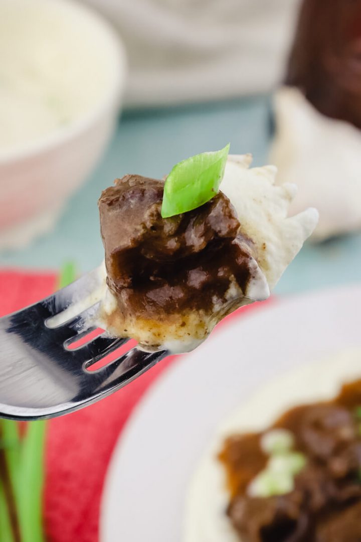 Bite on a fork of cauliflower mashed potatoes and keto beef tips with gravy