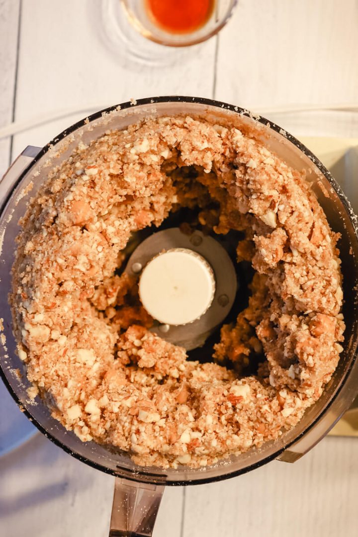 Overhead view of a food processor with keto cheesecake butterscotch bars dough