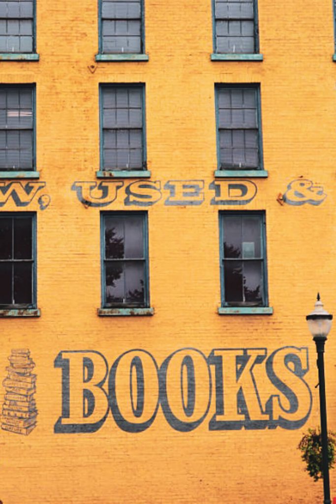 Outside view of yellow building on which is written "books"