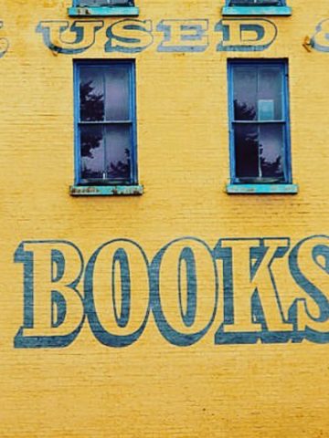 Outside of yellow building on which is written "books"