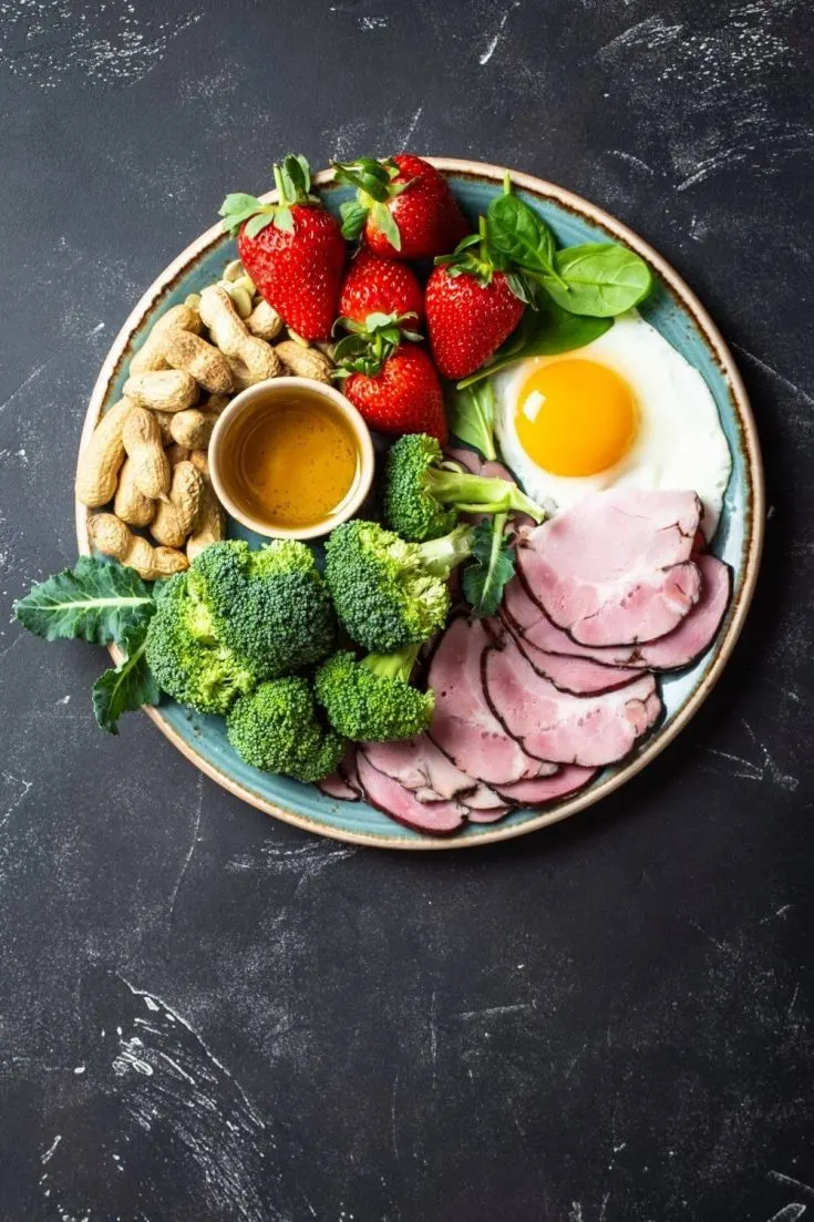 Plate of eggs, strawberries, peanuts, broccoli, etc.