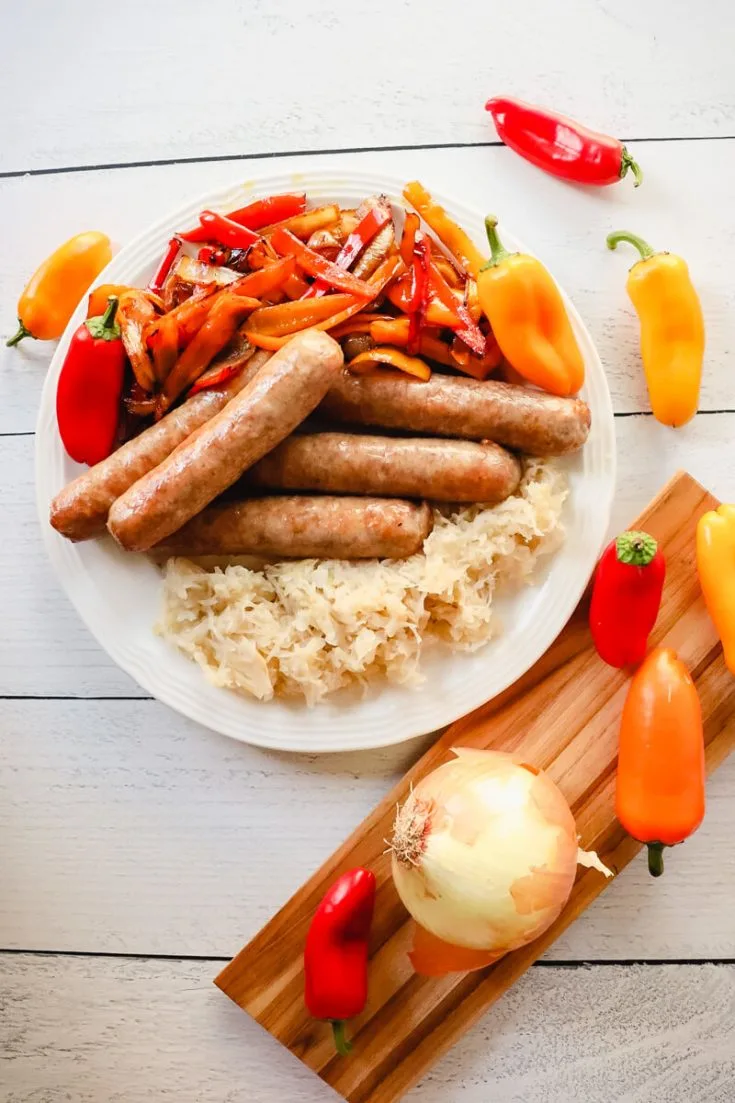Overhead view of brats with peppers and onions