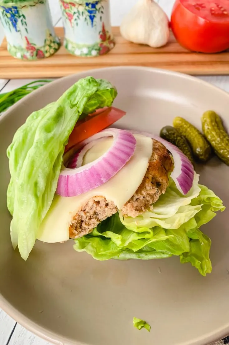 Bite out of a keto turkey burger on a plate