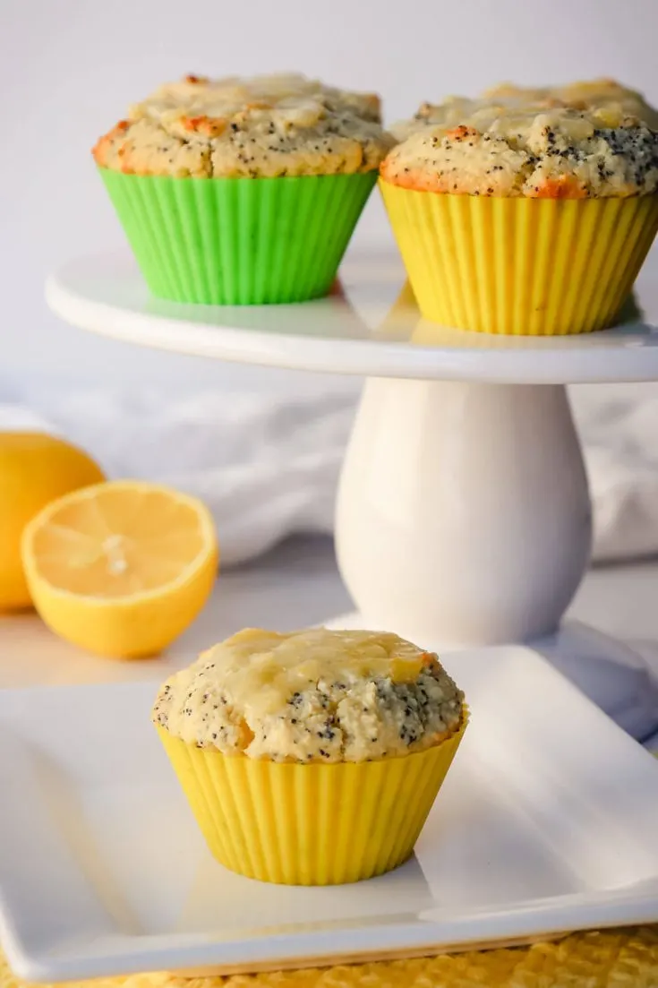 Keto lemon poppy seed muffins on a pedestal and plate
