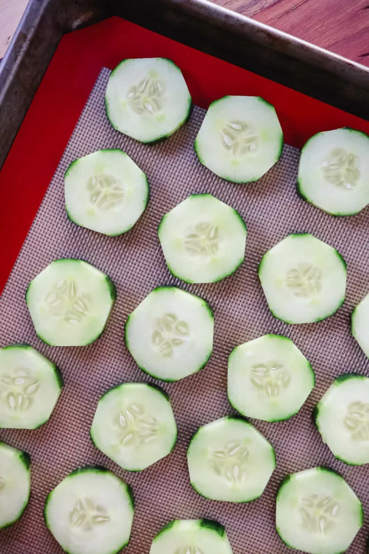 Overhead view of cucumber rounds on a pan