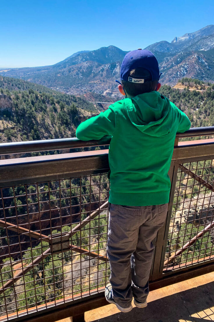 Boy looking out over a mountain view from Cave of the Wonds