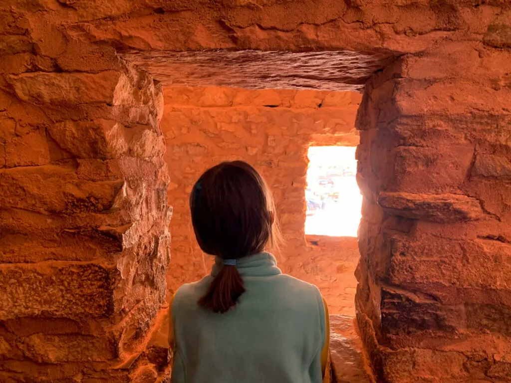 Girl looking out a window at the Manitou Cliff Dwellings