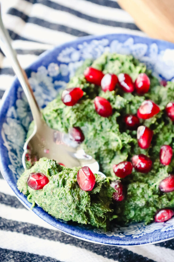 Bowl of spinach pkhali salad with pomegranate seeds
