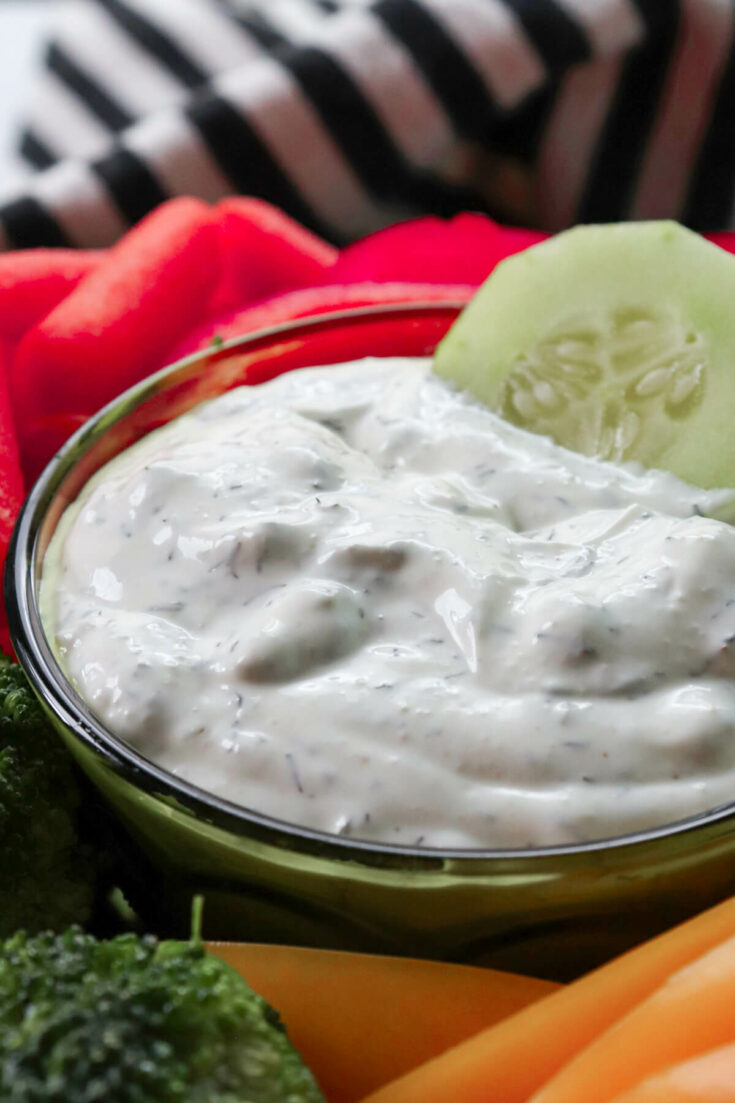 Bowl of low carb dill dip with a cucumber