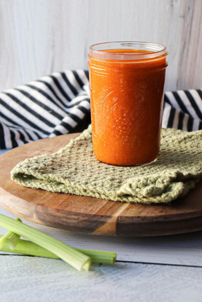 Keto Buffalo sauce in a jar sitting on a green crocheted towel