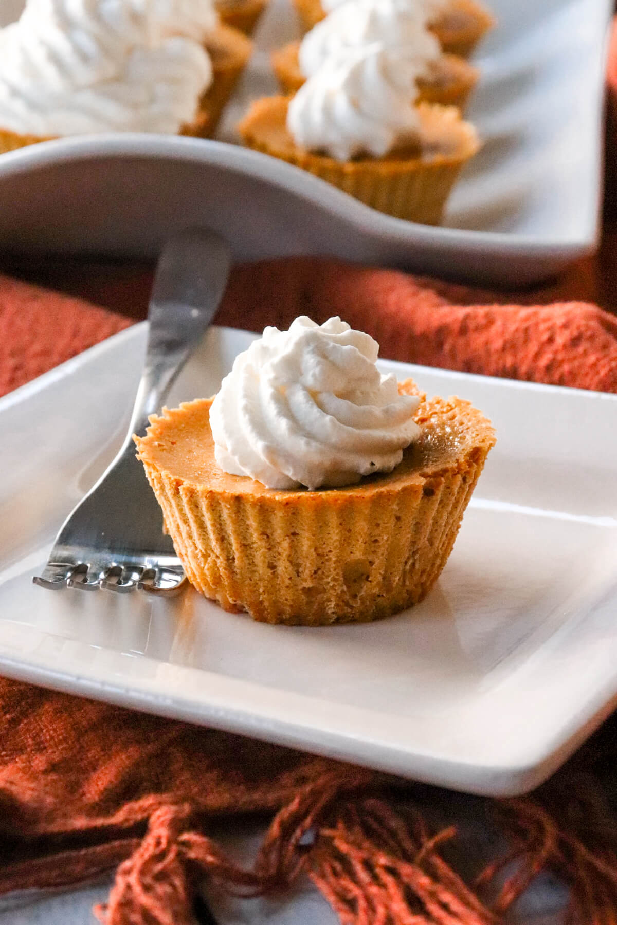 Mini keto pumpkin pie on a plate with more in the background