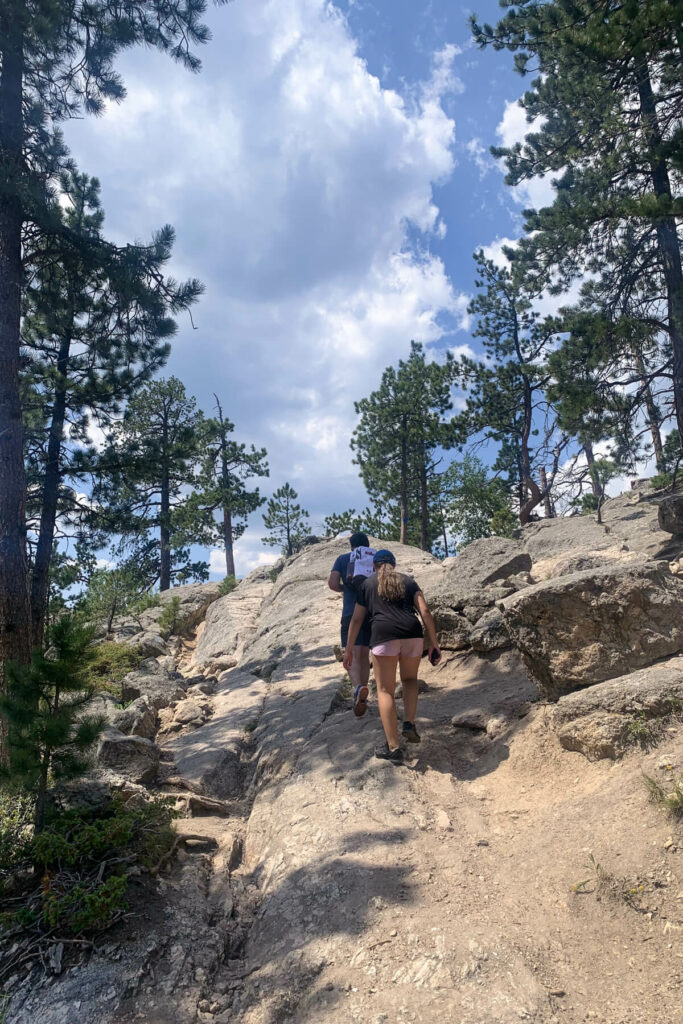 A man and girl hiking up a rock trail