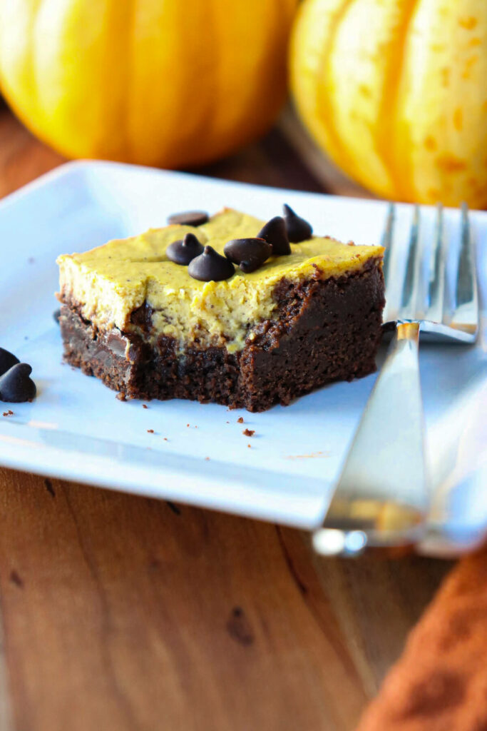 A keto pumpkin brownie on a white plate with a bite taken out