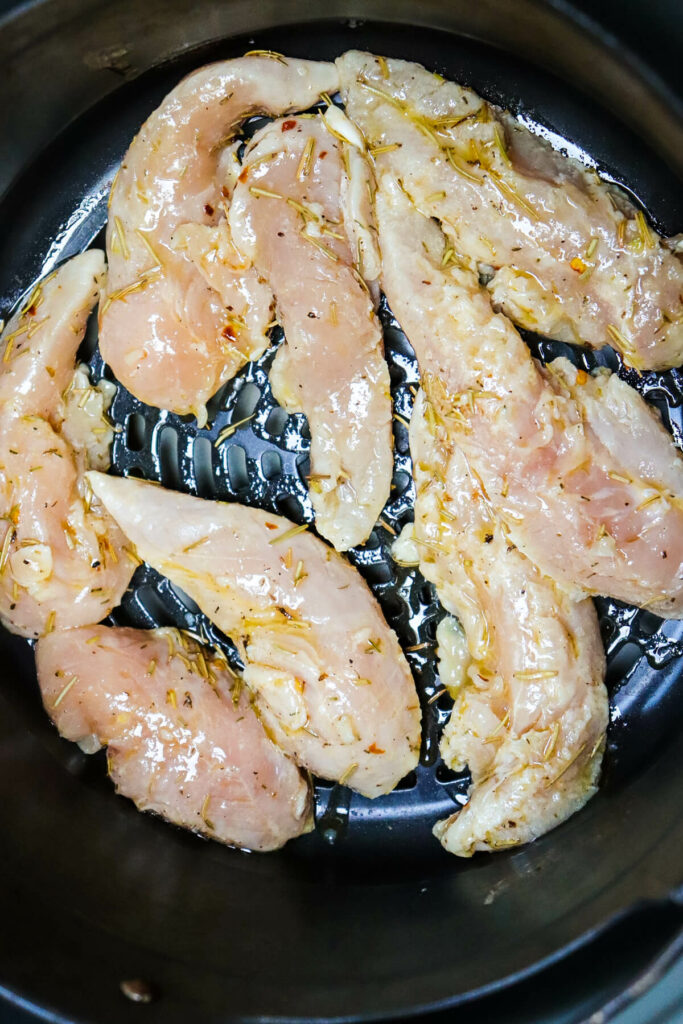 A layer of chicken in the air fryer basket