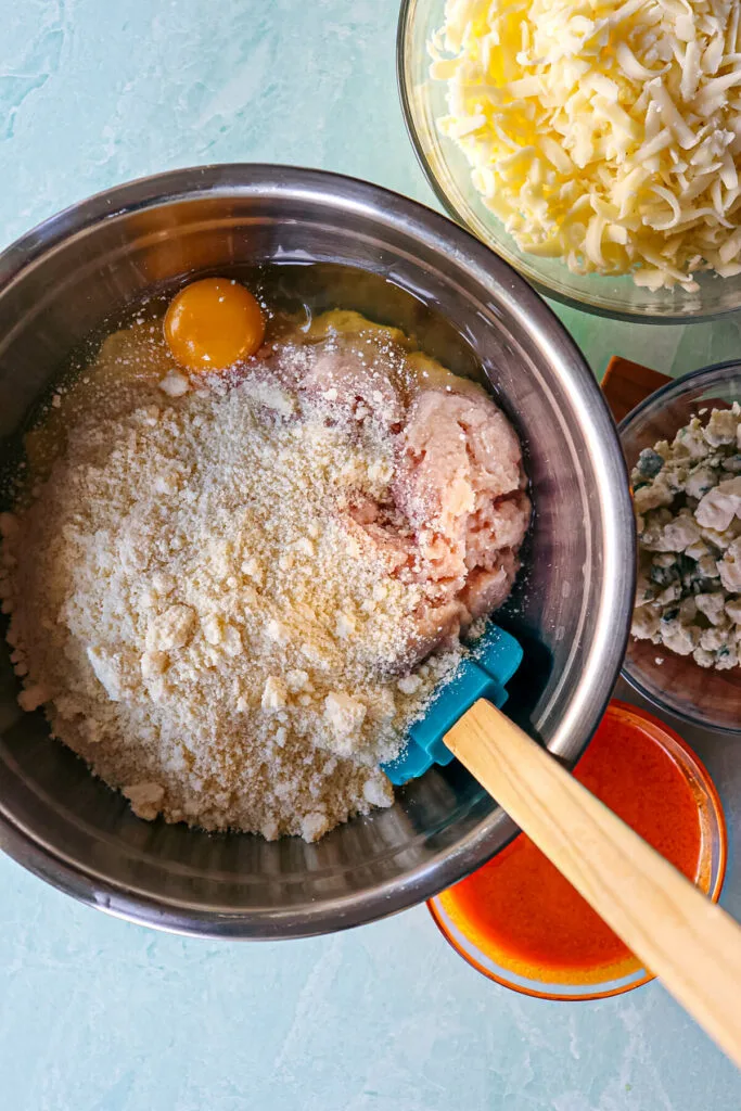 Ingredients for chicken pizza crust in a metal bowl, overhead view