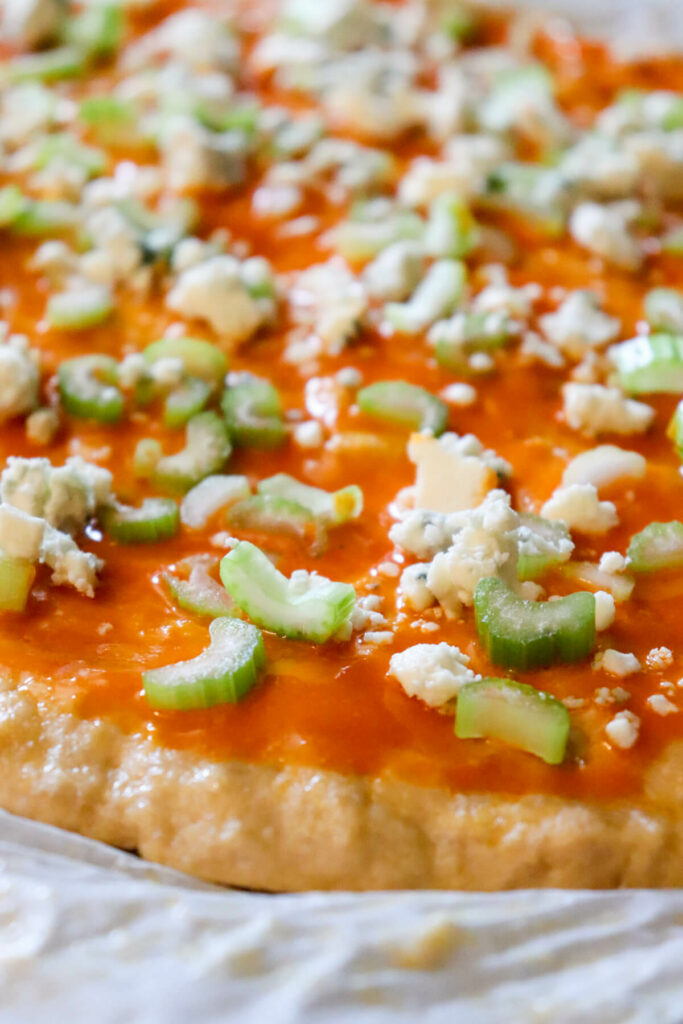 Pizza with hot sauce celery and blue cheese crumbles