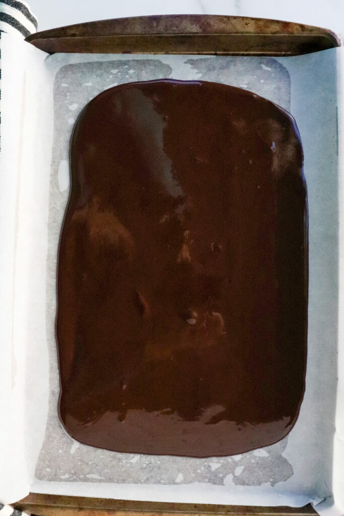 Chocolate poured and spread out on a baking sheet