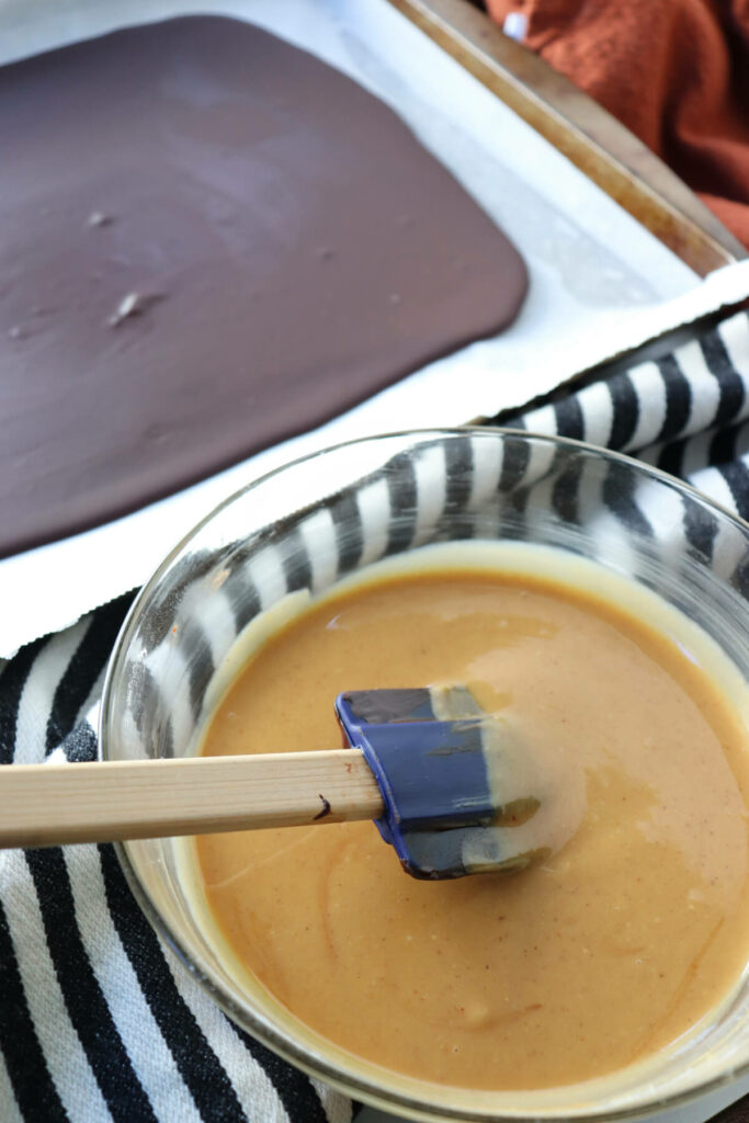Pan with chocolate and a bowl of melted cocoa butter and peanut butter