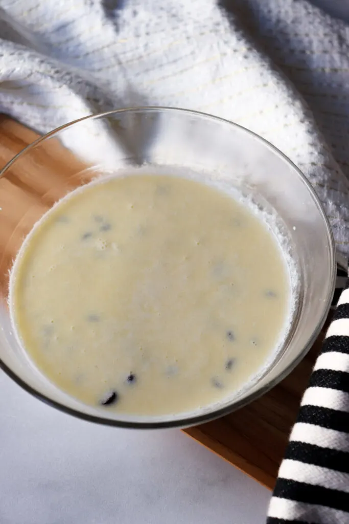 A glass bowl with chocolate chips and heavy cream