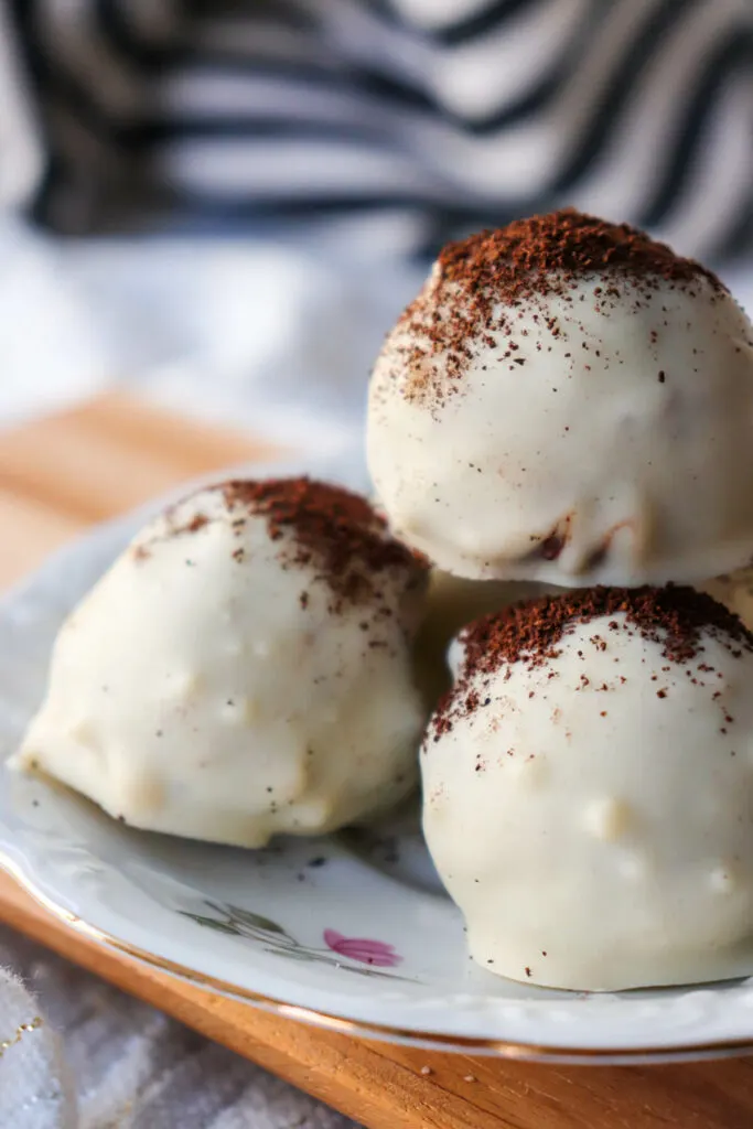Three keto tiramisu truffles stacked on a plate