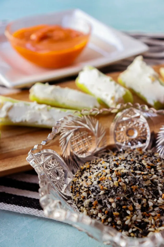 Bowl of everything bagel seasoning with stuffed celery in the background