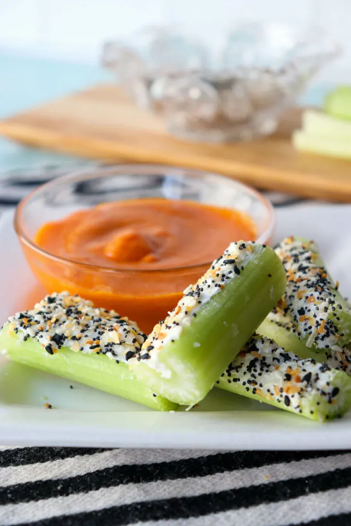 Easy keto celery snacks with keto Buffalo sauce for dipping on a white plate